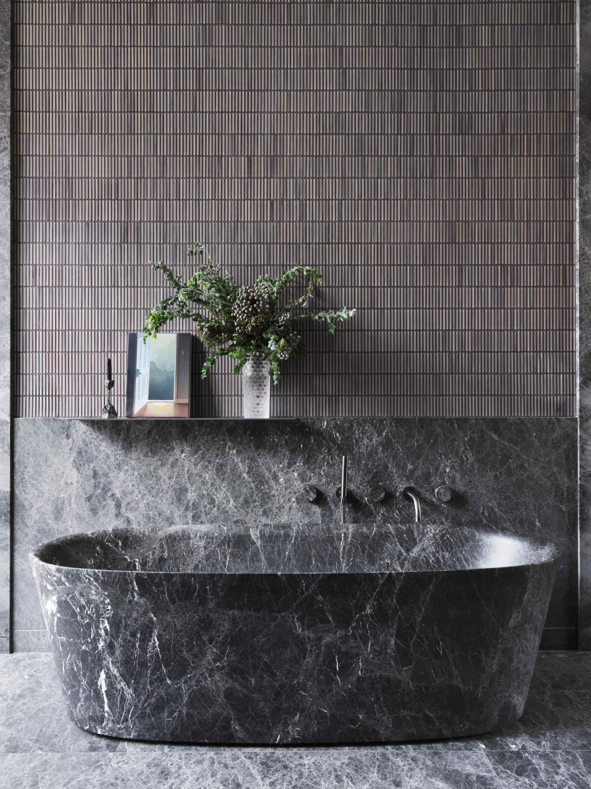 The dark, sophisticated palette brings a sense of calm and luxury to the bathroom
