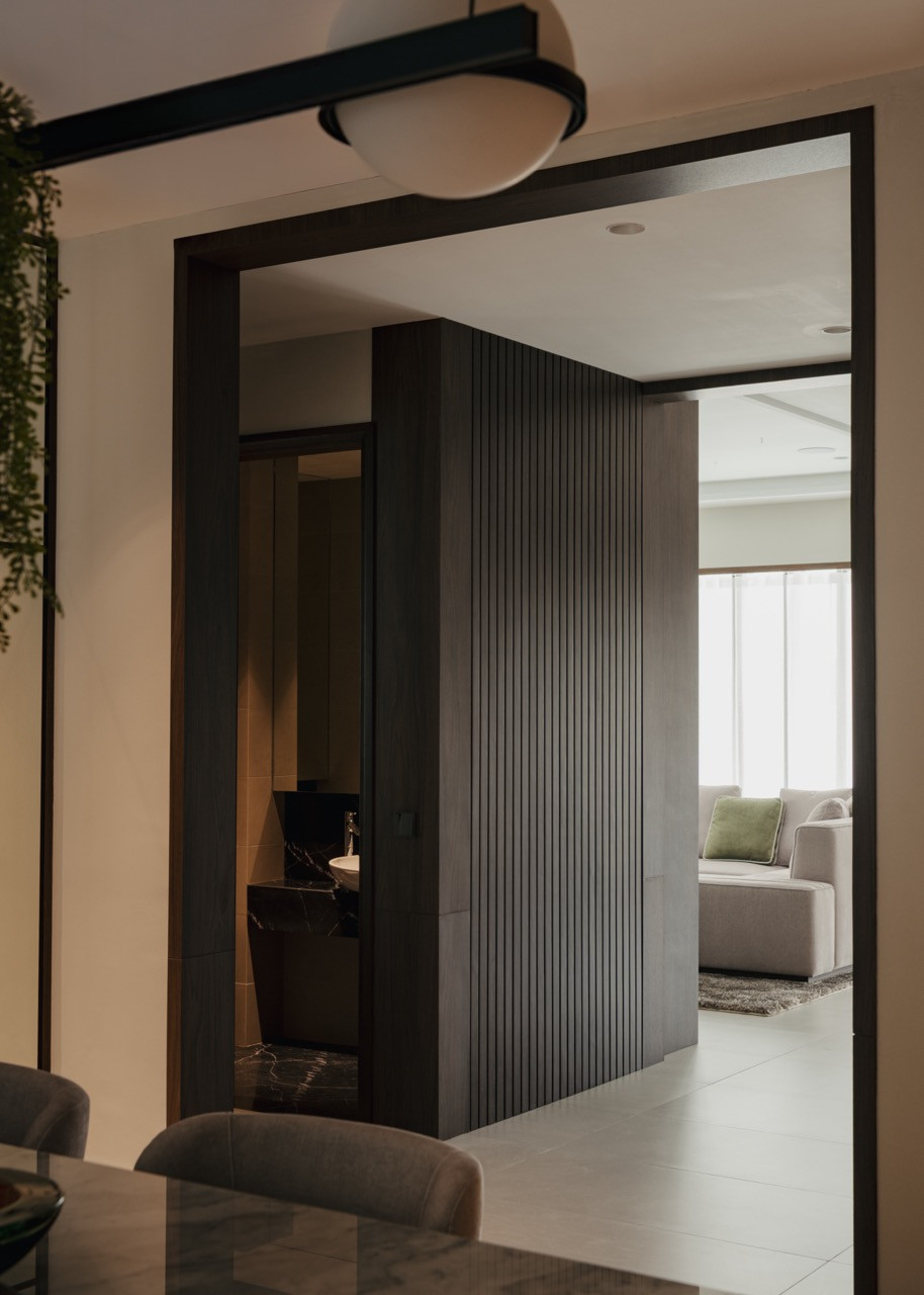 Framed openings with dark timber create visual connections between spaces while maintaining distinct zones