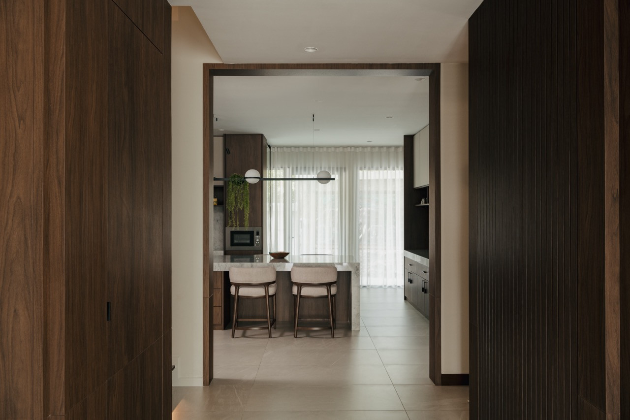 A view through the home shows the spatial flow created by removing structural obstacles, with timber frames creating transitions between the different floor levels