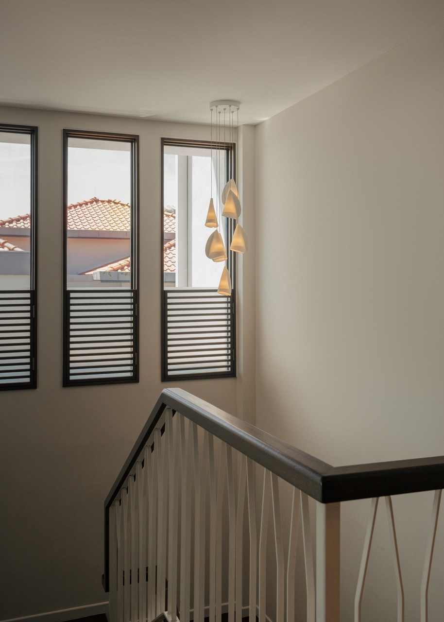 The stairwell features Bocci 21.7 Random pendant lights by Omer Arbel, that transitions the home from bright daylight to atmospheric evening moods.