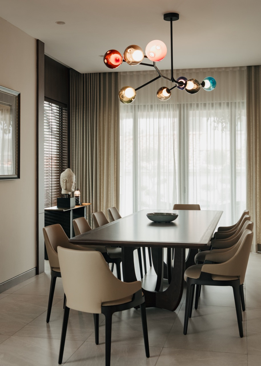The dining room features the sculptural chandelier, creating a dramatic colour contrast above Velis’ dining chairs