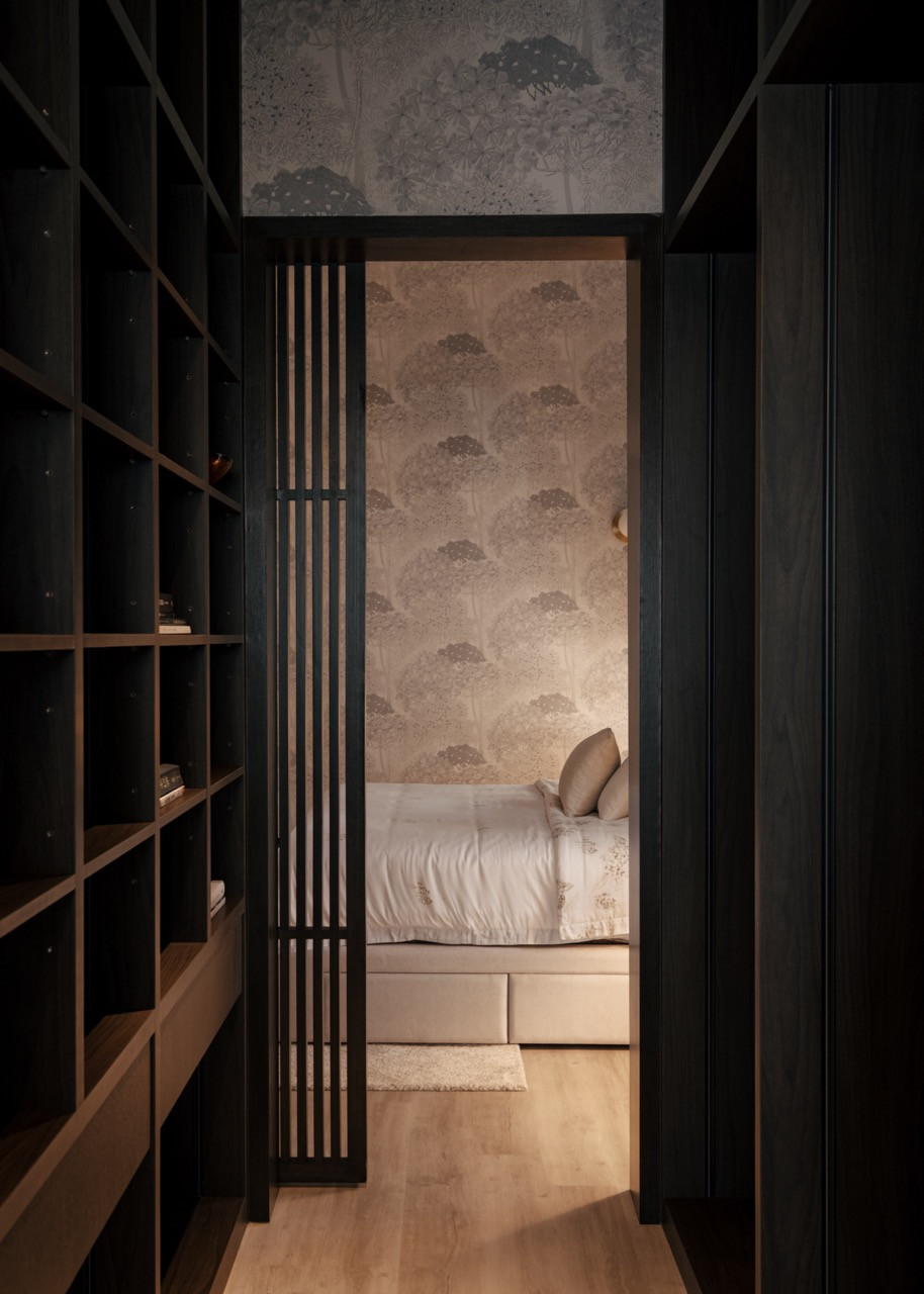 The walk-in closet features dark timber shelving and displays the careful balance between the owner's eclectic collections and organised storage solutions