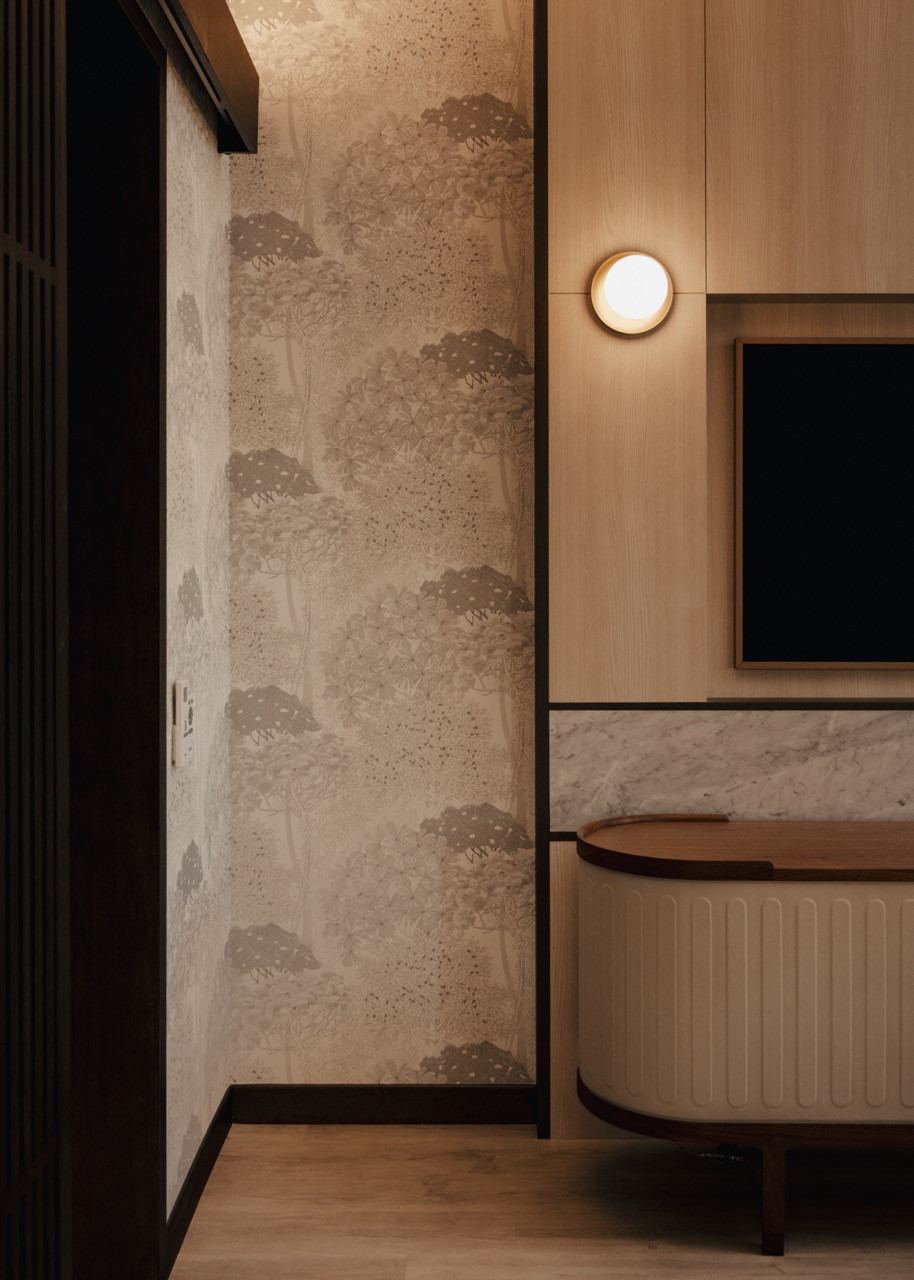 Custom timber cabinetry frames entertainment areas with circular wall sconces providing ambient lighting throughout