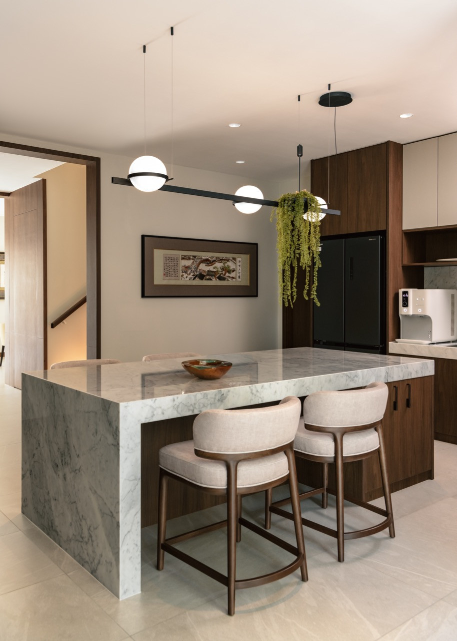 The kitchen island showcases white Carrara marble with Palma pendant lights by Antoni Arola for Vibia overhead