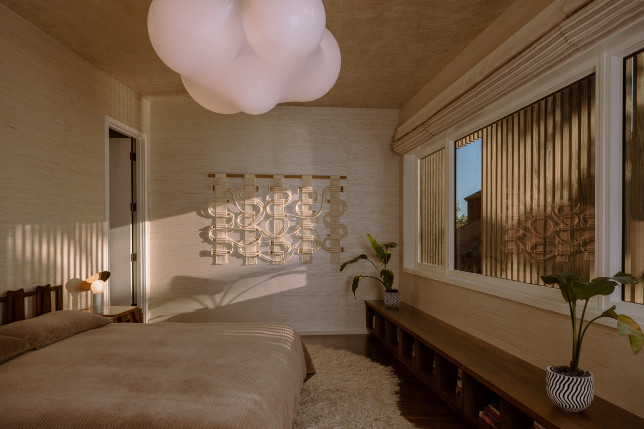 The primary bedroom includes an Axolight pendant, Windy Chien wall hanging, and grasscloth wallpaper with a Kush rug.
