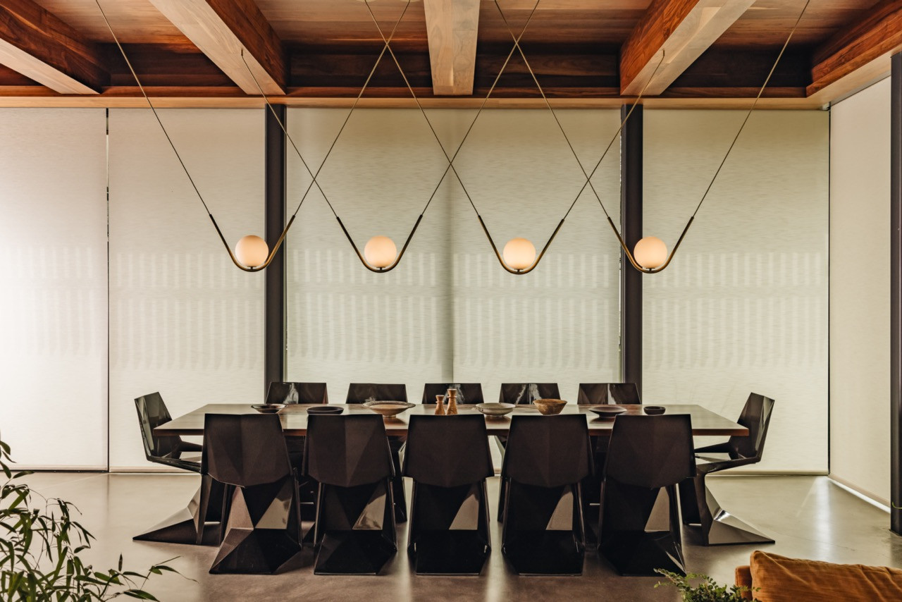 The dining area includes the couple’s 12-seat table by Costantini Design with Vondom chairs and a Larose Guyon chandelier suspended from the exposed beam ceiling