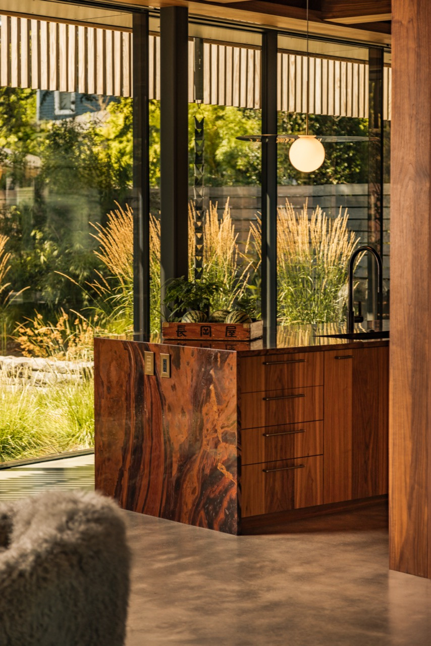 The kitchen’s Brazilian Mirage quartzite island with Pablo pendants above