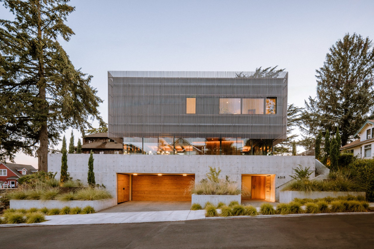 The exterior view showcases Waechter Architecture’s design, featuring thermally modified southern pine cladding, concrete retaining walls, and a landscape design by Lilyvilla Gardens in northeast Portland