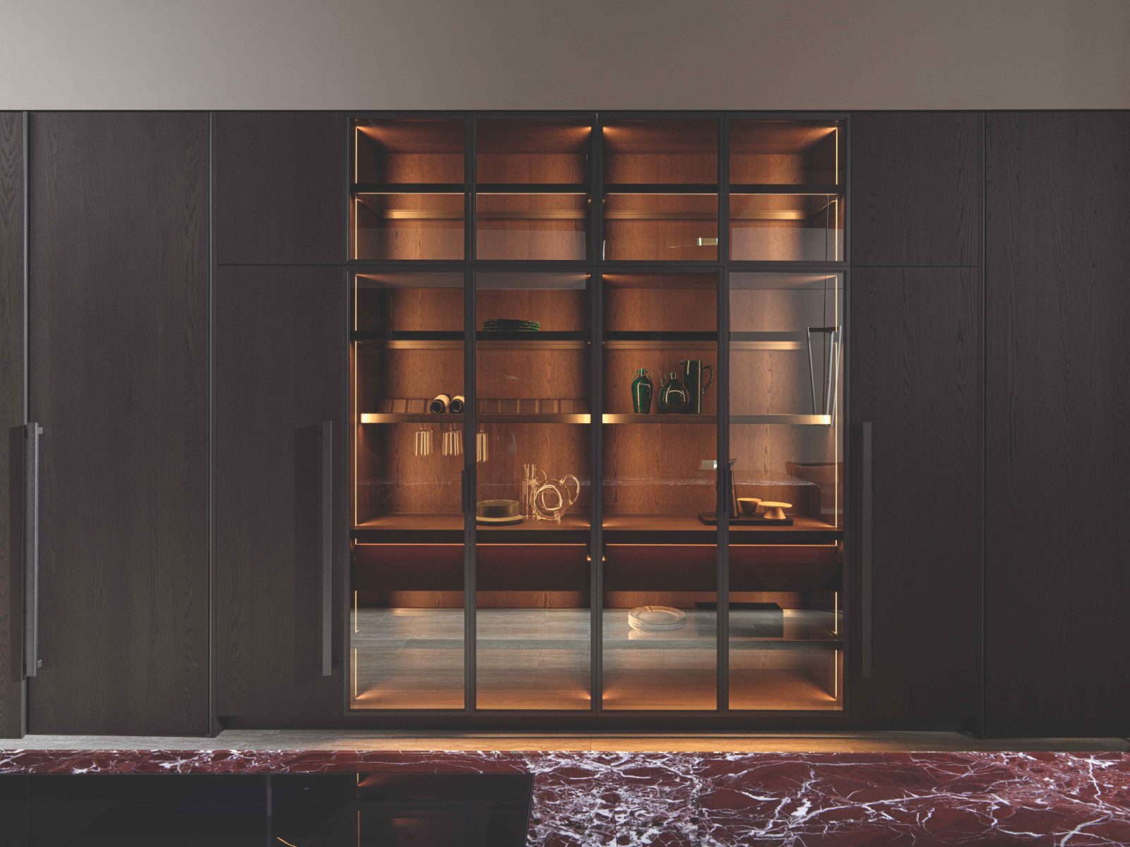 The kitchen cabinetry is conceived as a wardrobe of textures and tones, fitted with the PT40 door system with finger recess detailing
