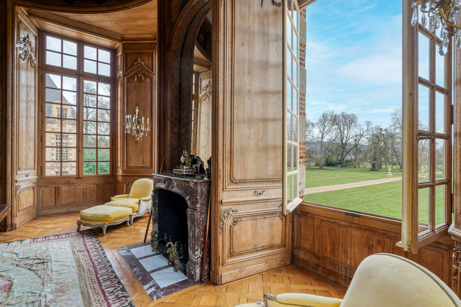 Reception room with floor-to-ceiling windows overlooking the estate grounds, demonstrating the sumptuous interiors mentioned in the restoration documentation