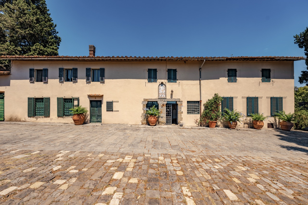 Farmhouse building at Castello di Vincigliata representing part of the over 1,100 square meters of additional structures beyond the main castle, offering development potential for accommodation or wine production at this historic European castle