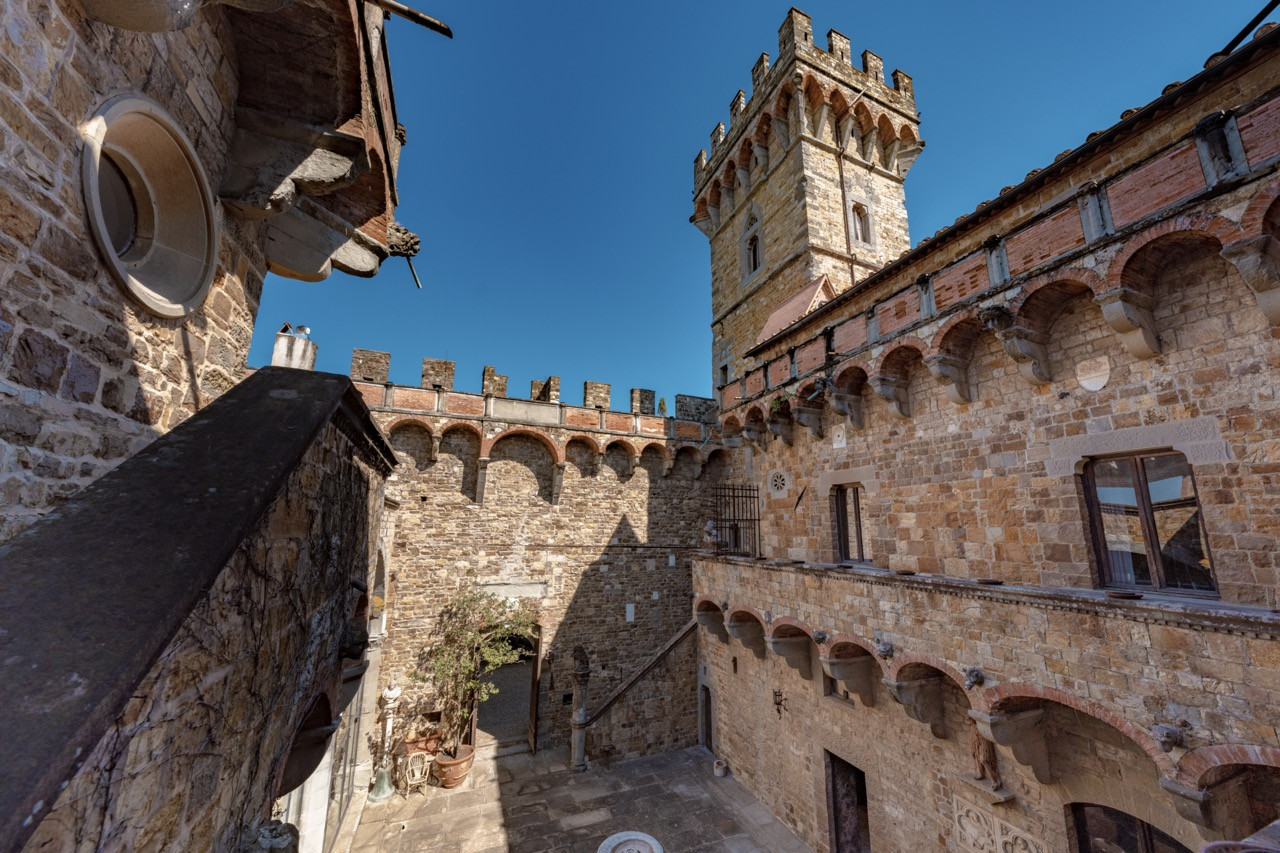 Castellated walls and defensive architecture at Castello di Vincigliata, showing the medieval fortification elements preserved in this historic European castle that once hosted Queen Victoria in 1893