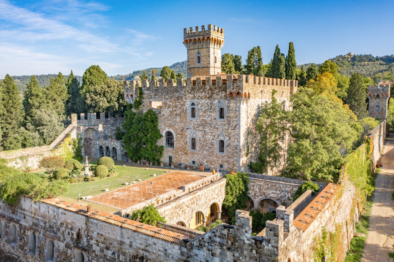 Complete castle complex at Castello di Vincigliata viewed from above, showing the relationship between the main tower, courtyard, and estate buildings across this historic European castle's 34.79-acre property