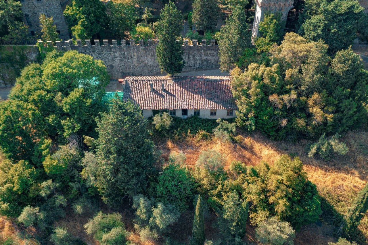 Aerial view of estate buildings at Castello di Vincigliata nestled within the castle walls, showing part of the additional development potential beyond the main 985-square-meter castle at this historic European castle property