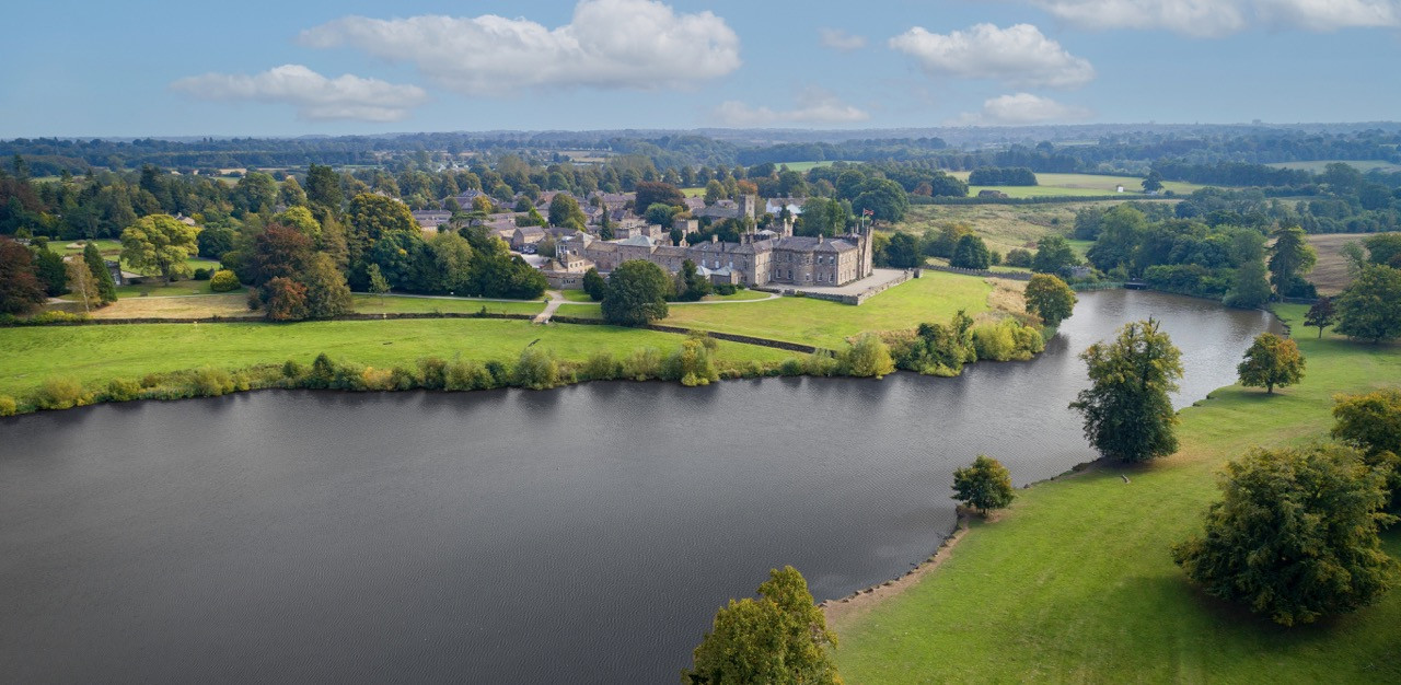 Ripley Castle and village viewed from the lakeside showing the relationship between the historic European castle and surrounding community within the 165+ acre estate that includes ornamental gardens and deer park