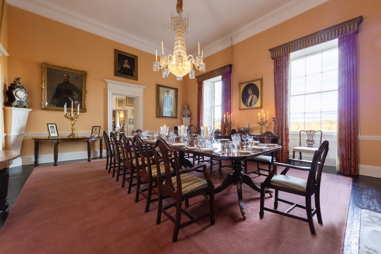 Formal dining room with crystal chandelier and family portraits at Ripley Castle, showcasing the elegant entertaining spaces within this historic European castle owned continuously by the same family