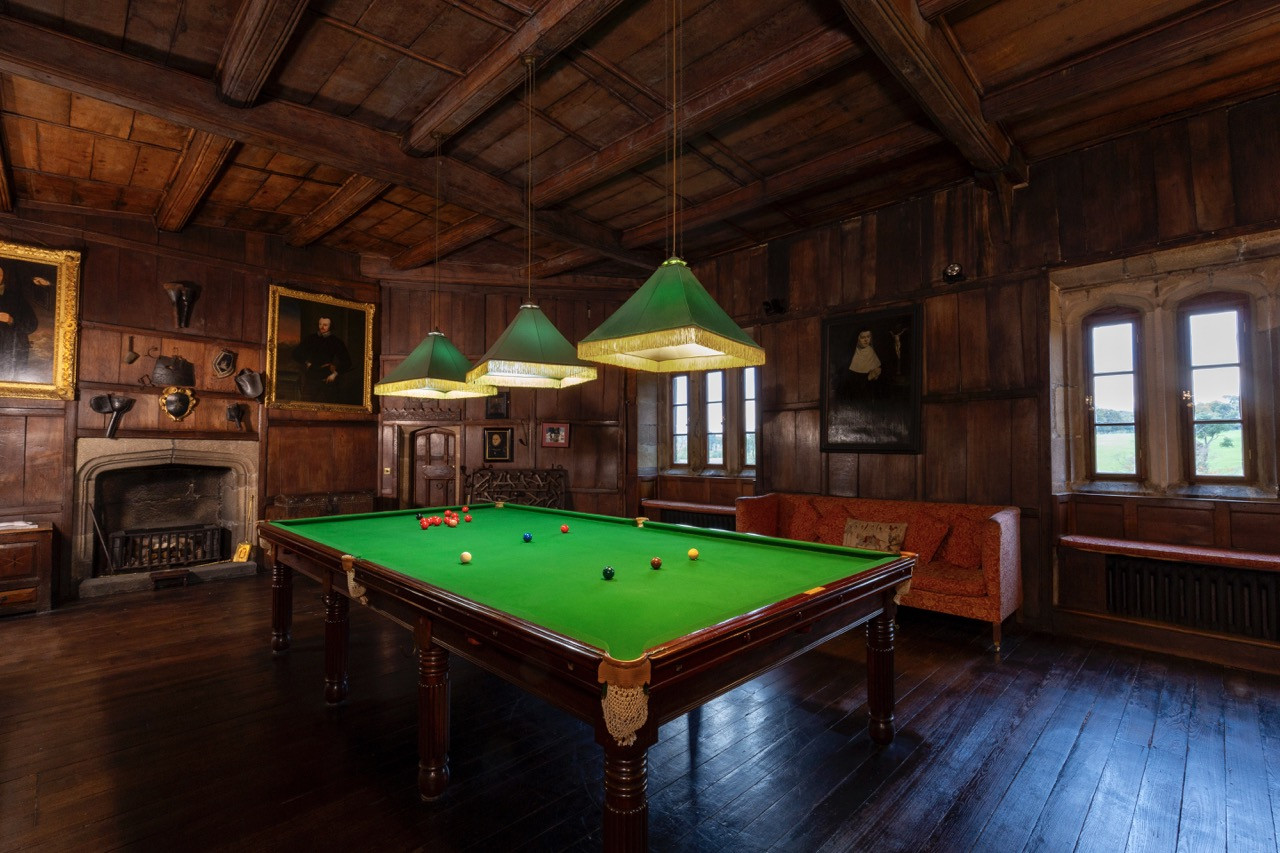 Billiards room with exposed beam ceiling at Ripley Castle showing the recreational facilities within this historic European castle that successfully combines heritage preservation with modern hospitality business