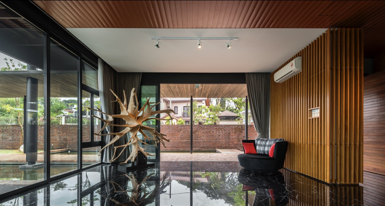Main living area opening onto verandah through floor-to-ceiling glazing, with timber louvre screens providing solar control