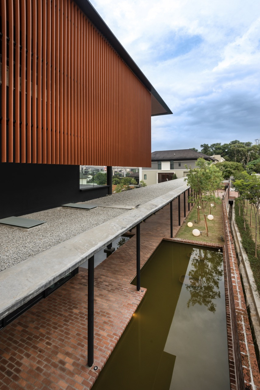 The 70-metre verandah with reflecting pools and clay brick paving frames views toward Kuala Lumpur's skyline.