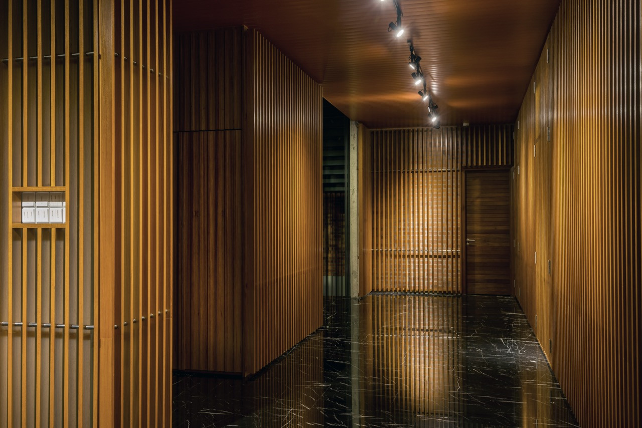 Timber louvre details creating geometric patterns with black stone flooring reflecting architectural elements