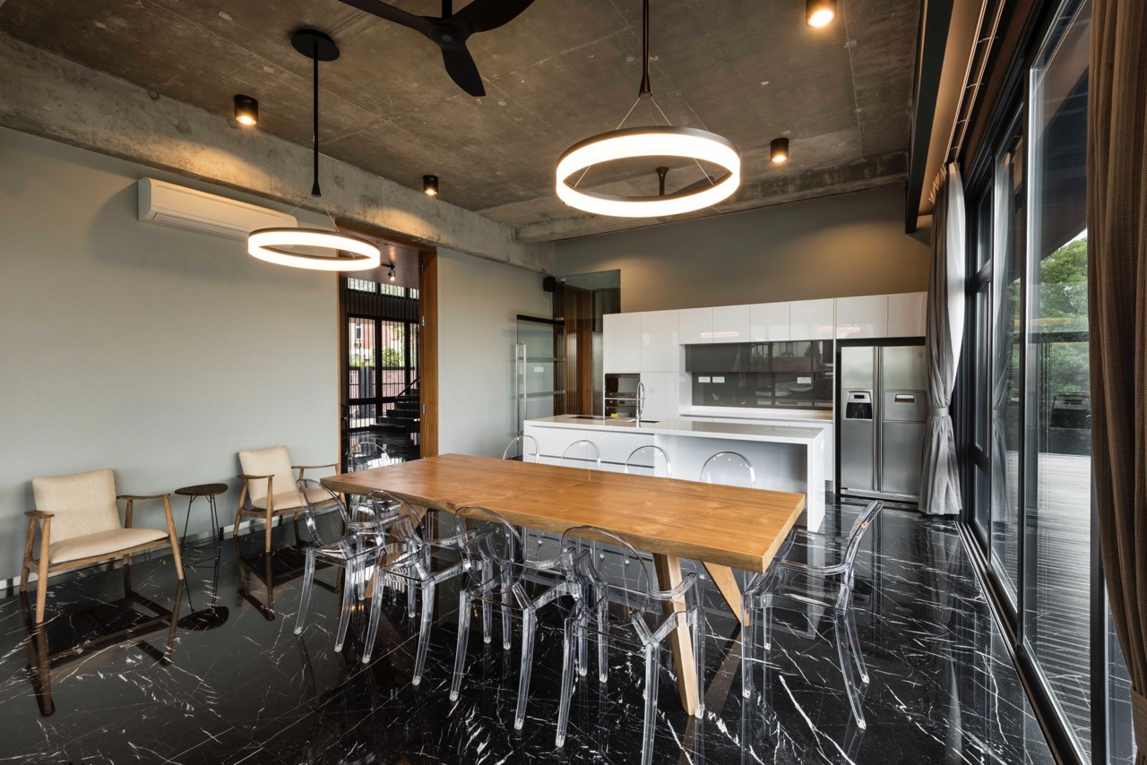 Alternative view of dining area emphasizing material palette of timber, concrete, and glass with neighbourhood views