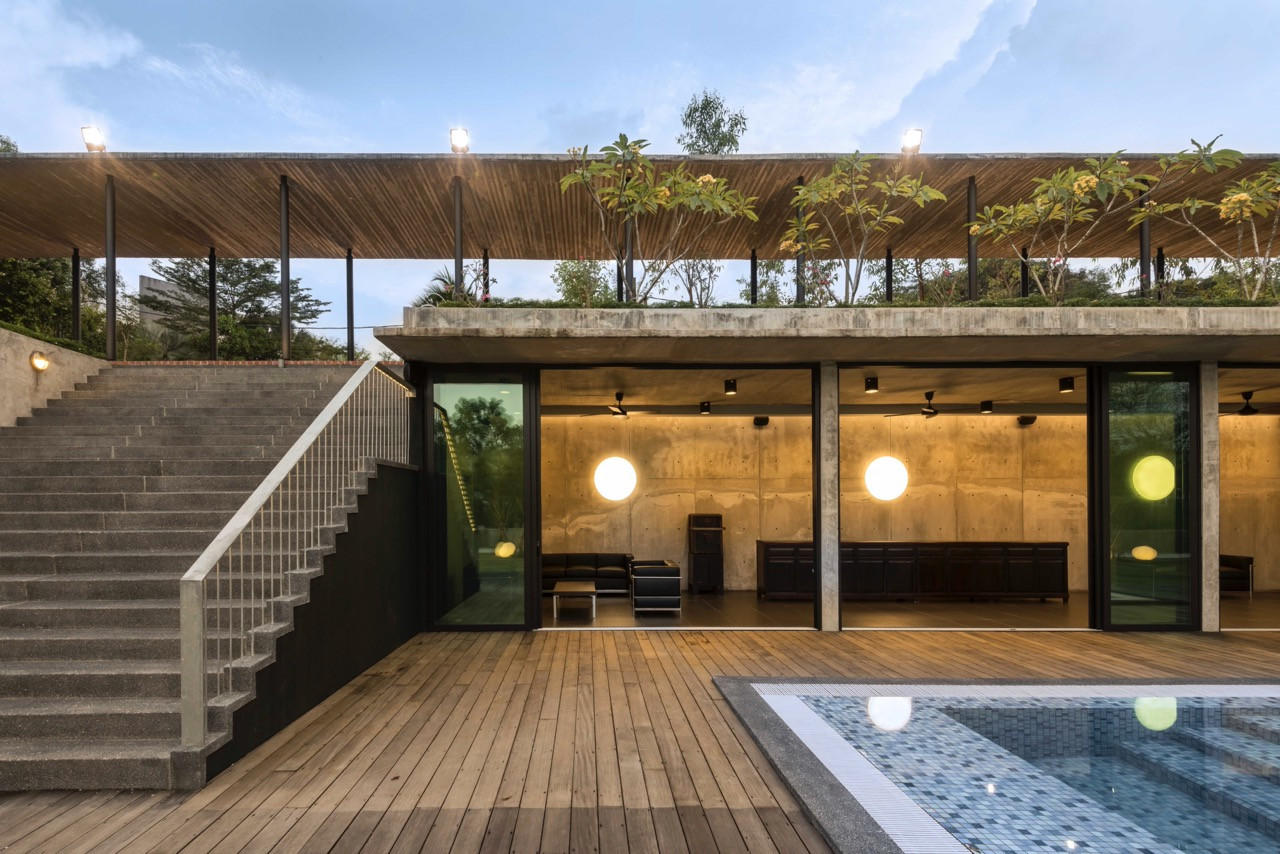 Evening view of pool level with concrete structure, timber decking, and spherical lighting connecting to upper levels