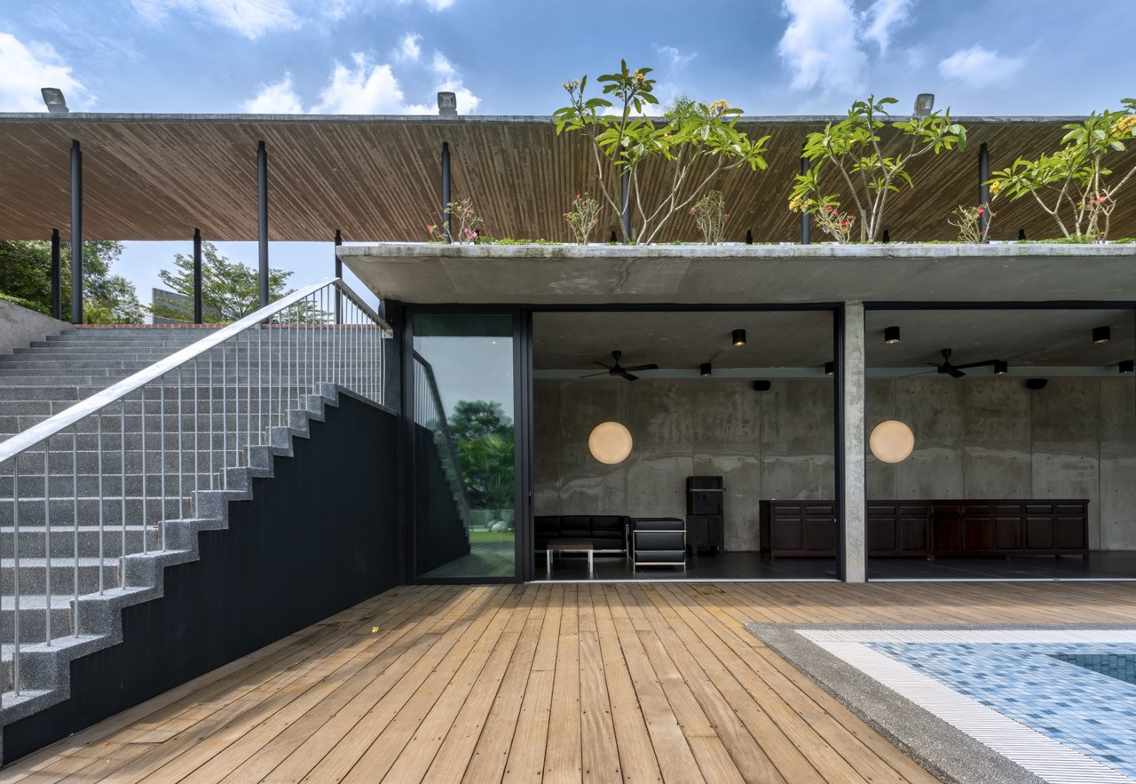 Timber decking around pool area with concrete steps and a planted terrace demonstrating level transitions