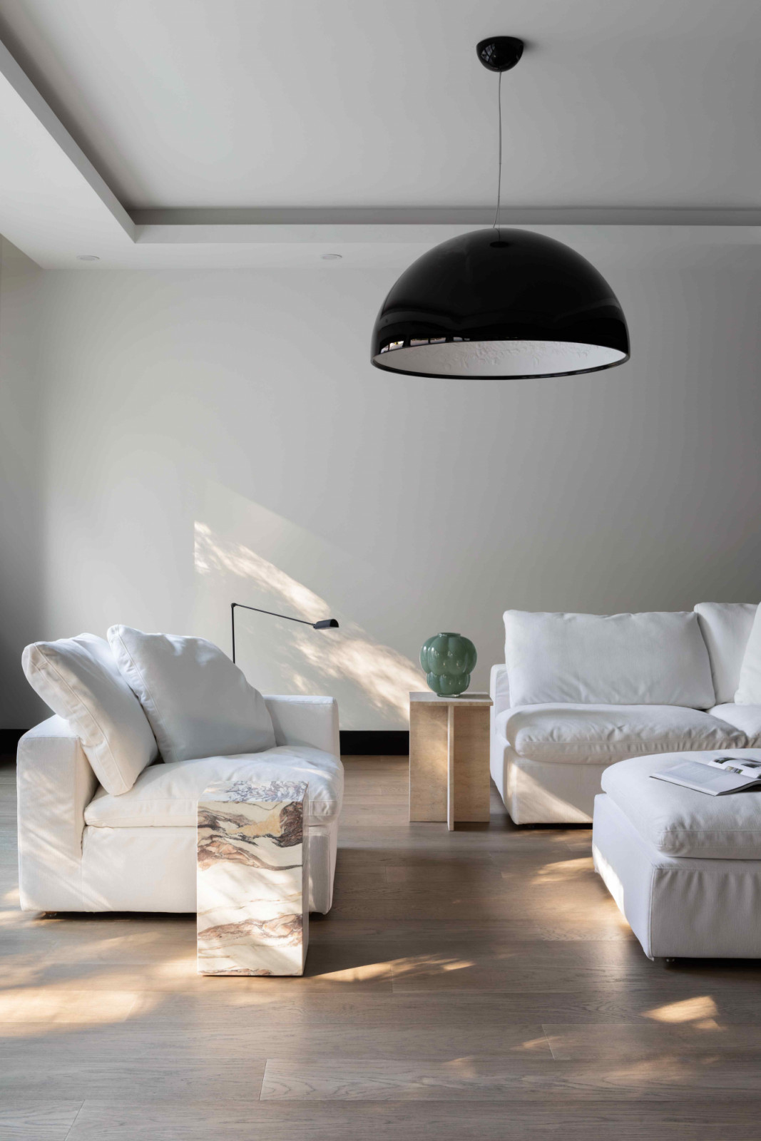 A striking Bocci pendant hangs above the crisp RH Cloud sofas