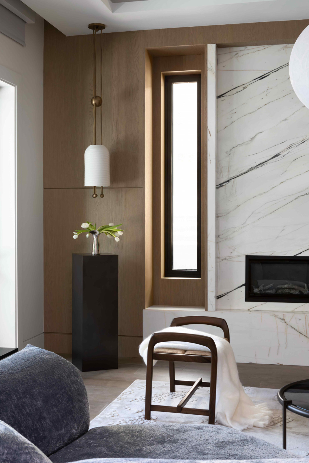 Apparatus Studio pendants bring harmonious symmetry to the marble fireplace