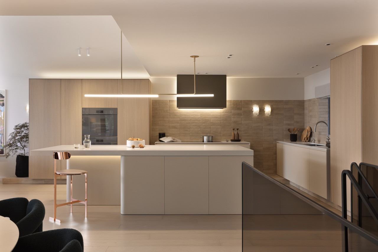 The kitchen's five furniture-like components are unified by Spanish porcelain tile that extends from floor to backsplash, with vintage crystal lighting adding texture and glamour