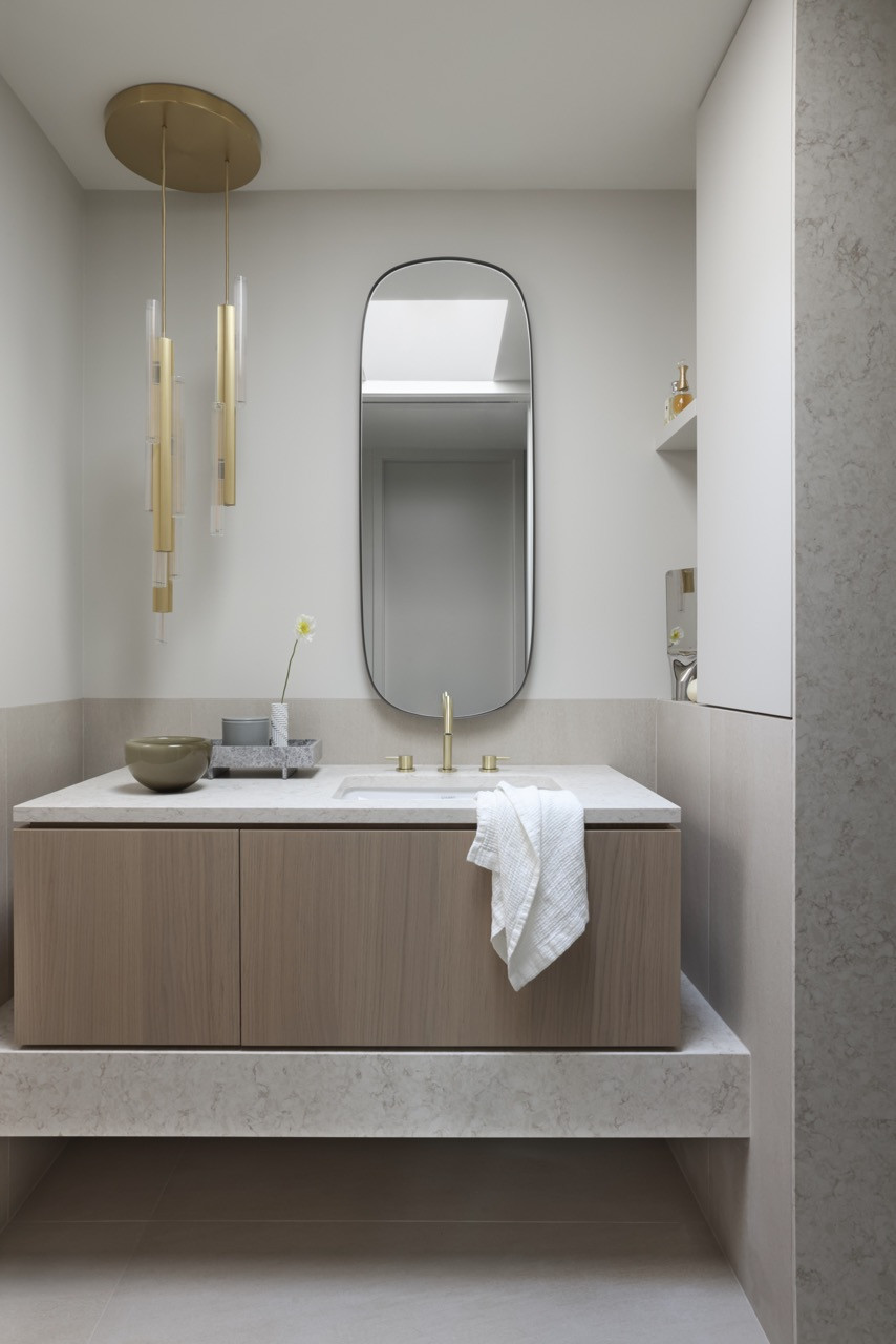 The primary ensuite bathroom features 14.1m pendants by Verpan and light hardwood millwork that extends throughout the home, creating a cohesive material palette