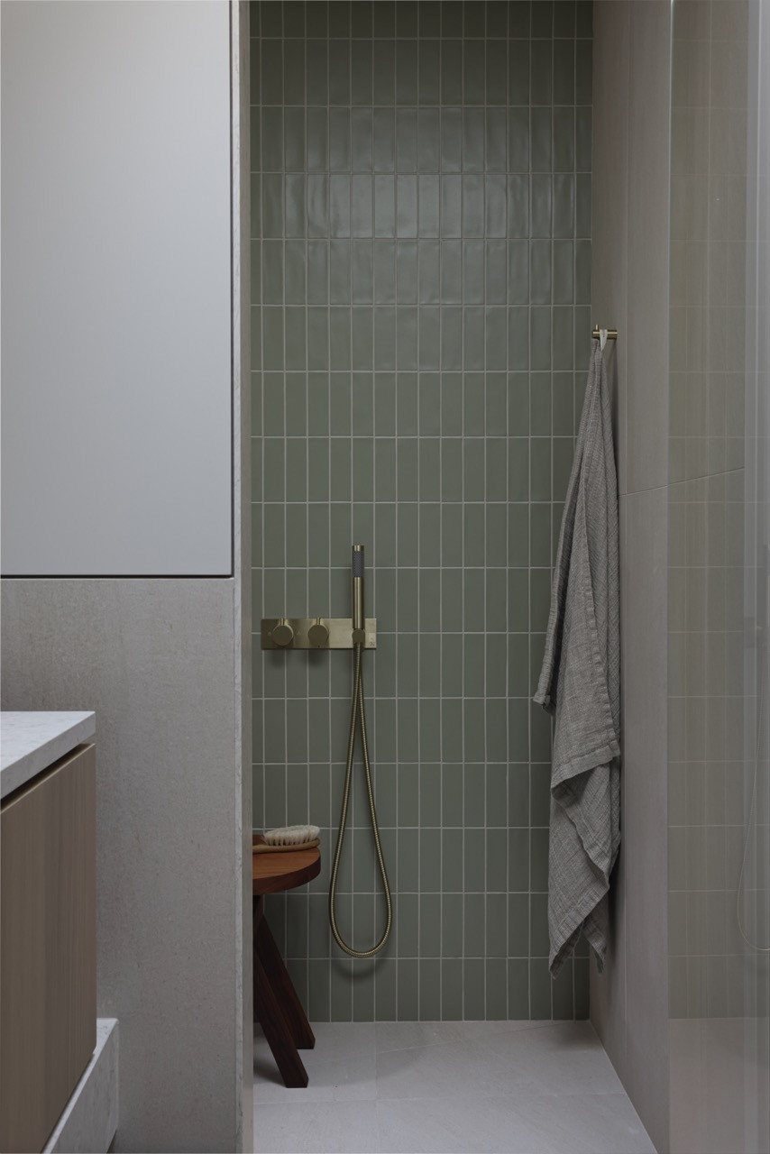 The shower features vertical lighting that creates ambient illumination for a relaxing spa-like experience, part of the thoughtful lighting strategy throughout the home