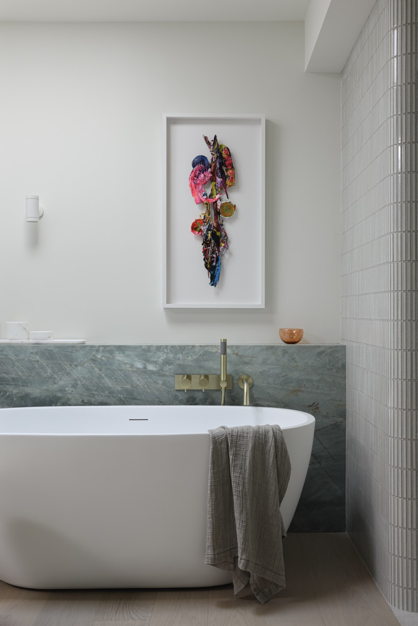 The primary ensuite features a Remnants sculpture by Carla Tak, demonstrating how the main floor serves as a gallery for the owner's art collection set on a warm palette that references a sandy beach