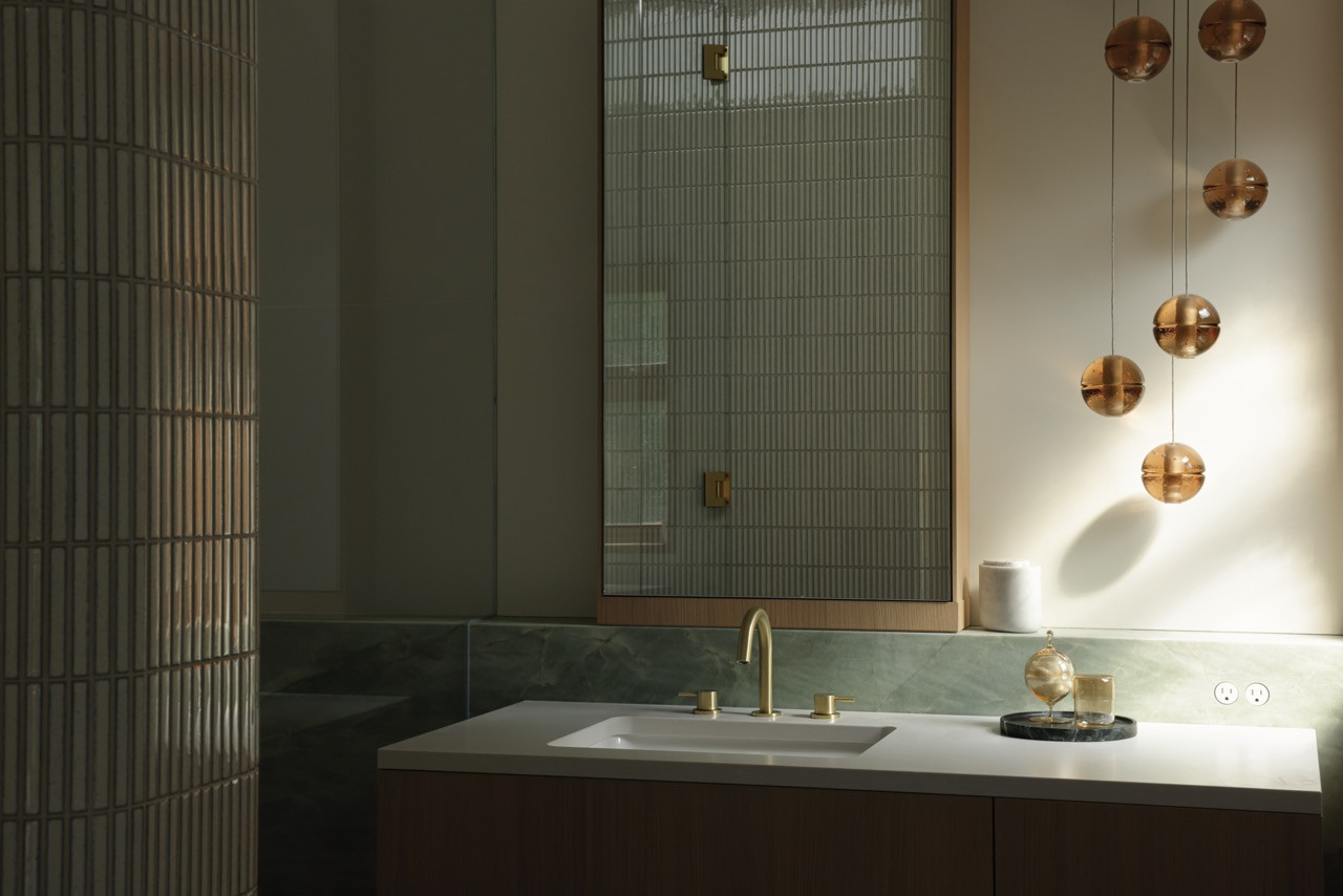 The primary ensuite features 14.1m pendants by Verpan and sophisticated material layering, with light hardwood millwork extending throughout the home to create a cohesive palette