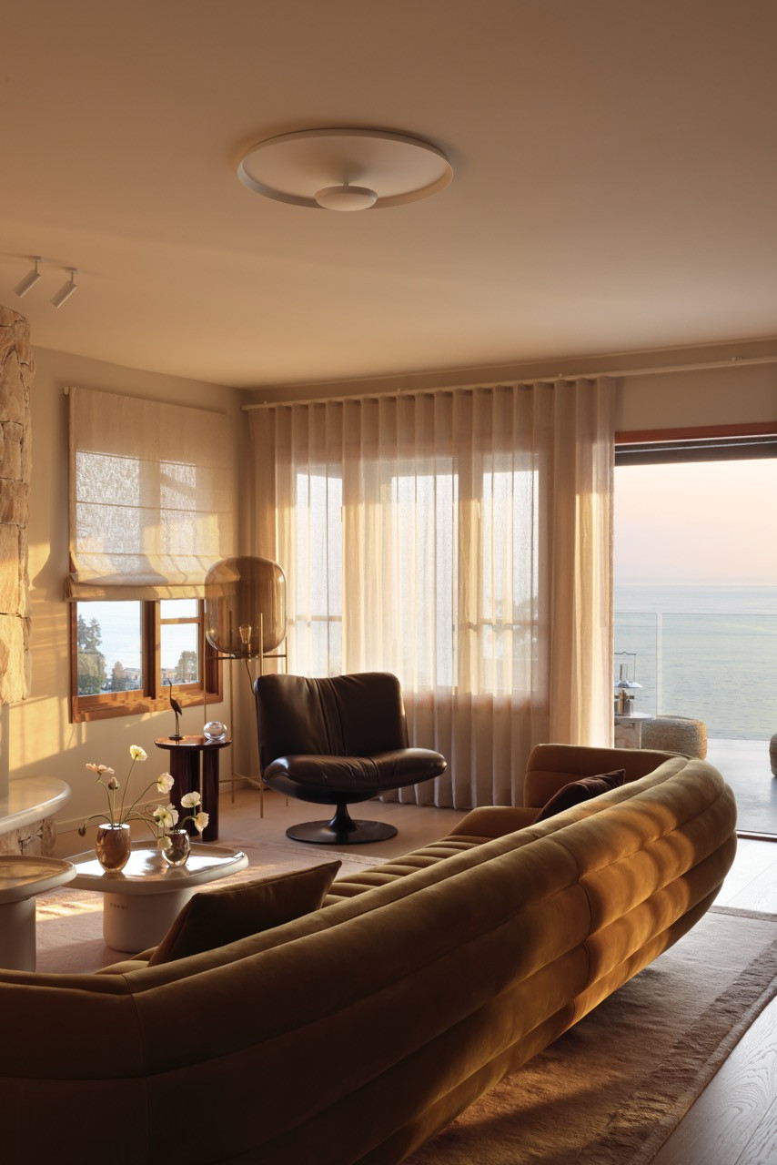 The sculptural Tactile sofa by Baxter anchors the living room, positioned to take advantage of the spectacular west-facing views whilst the curved onyx fireplace adds warmth and texture