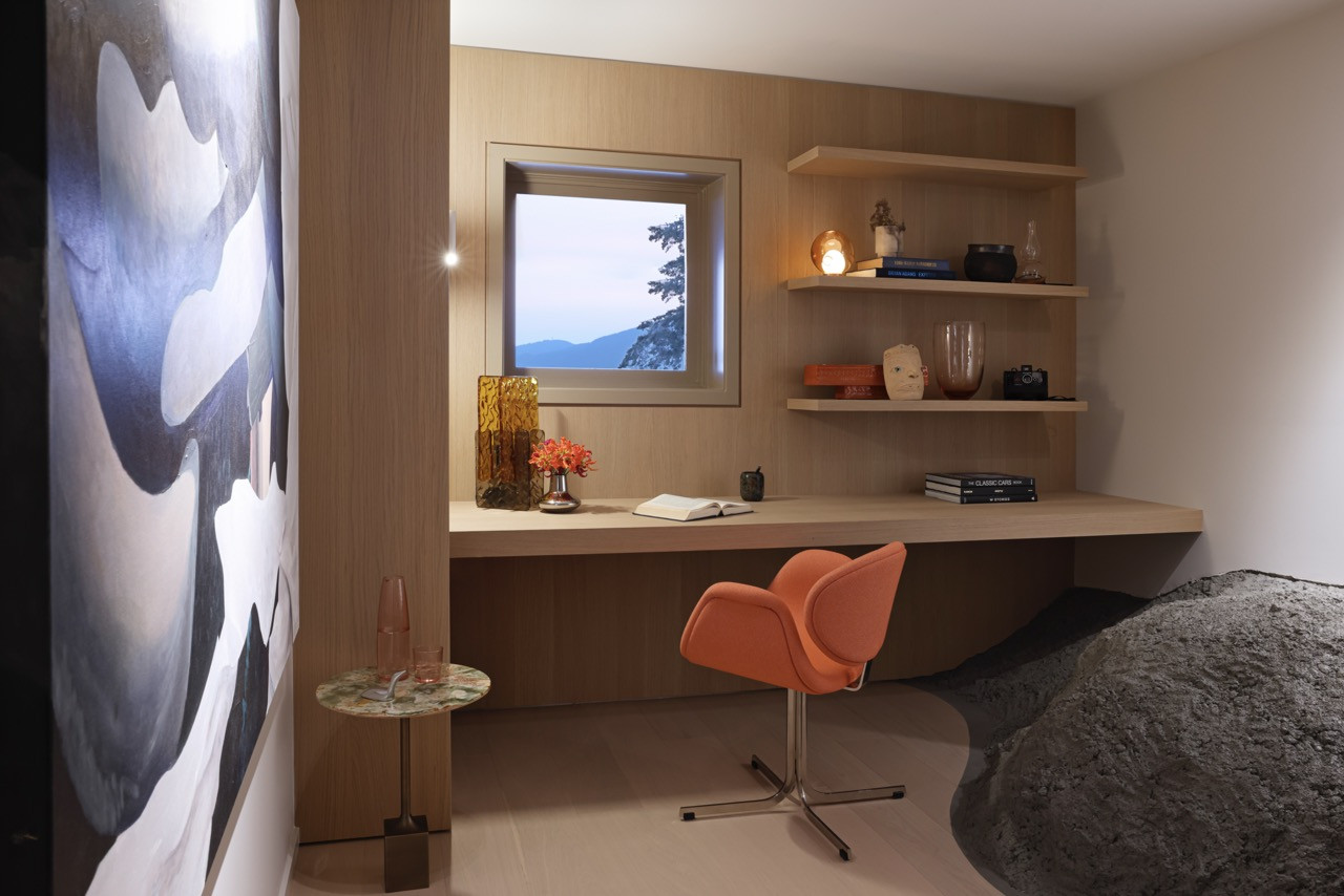 The lower-level office features light hardwood millwork and built-in shelving, with views overlooking Burrard Inlet from the home's clifftop position in Eagle Harbour