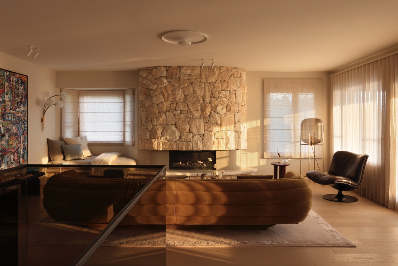 The living area showcases the reinstalled curved onyx fireplace, originally from 1975 but repositioned to preserve views whilst maintaining the home's vintage character.
