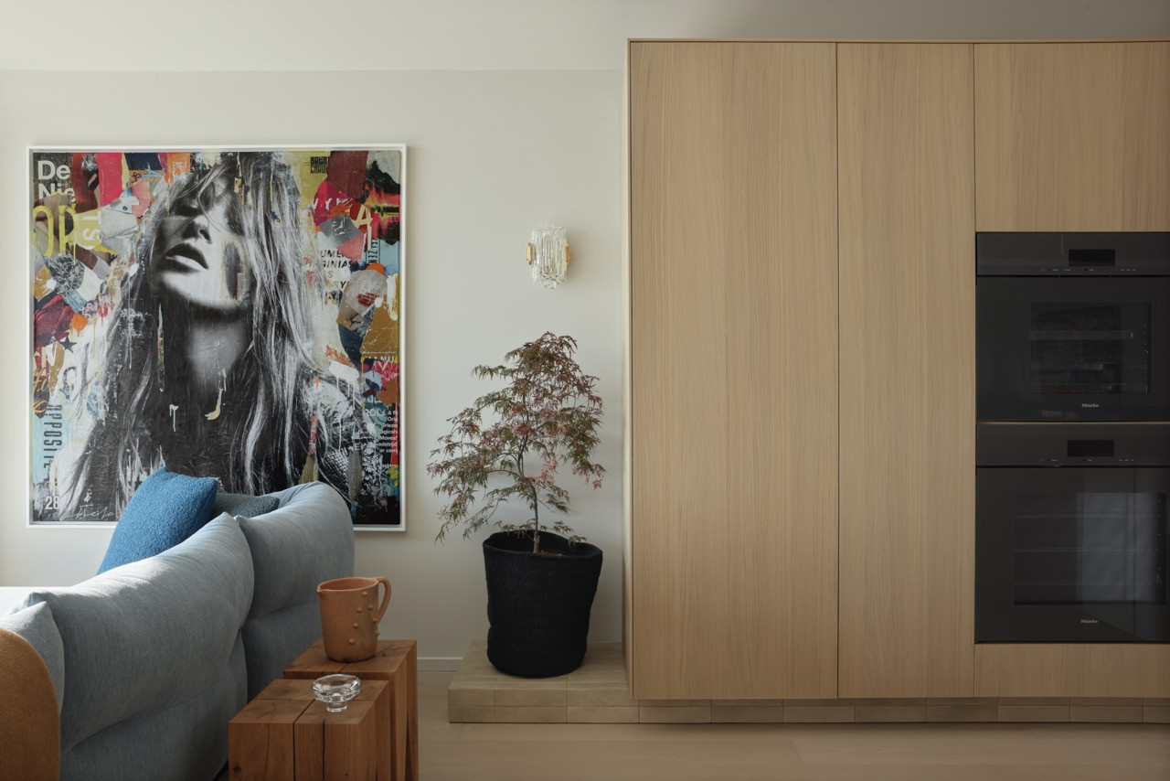 The family room features the Moncloud sectional by Cassina and collage artwork by Michiel Folkers, with the bronzed glass stair guard maintaining a visual connection between levels