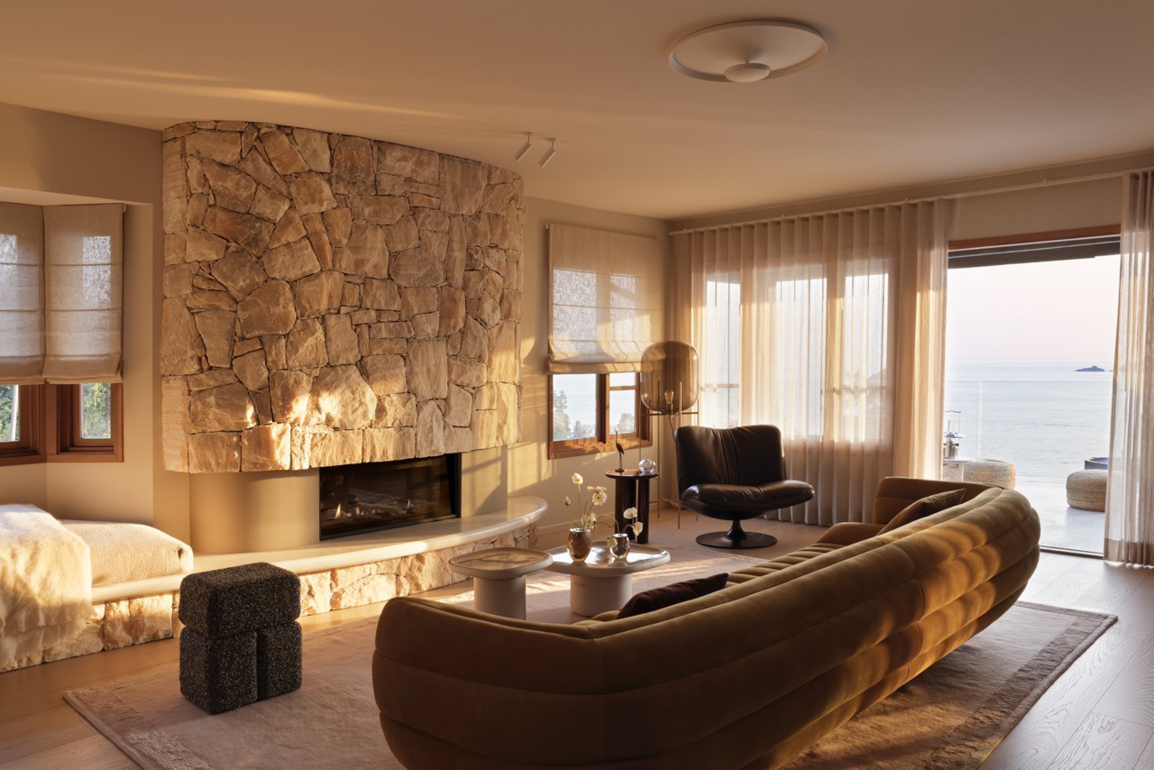 The main living space demonstrates the successful integration of the curved onyx fireplace with the Tactile sofa by Baxter, creating a space that feels like “a warm hug from a favourite friend"