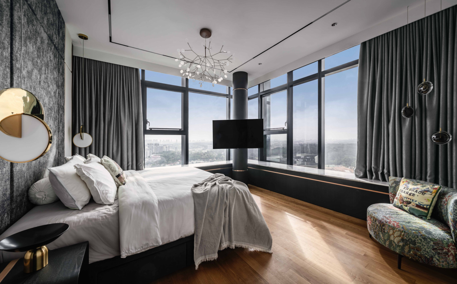 Dressed in greys and low-saturation florals, this bedroom with a view cleverly mounts the TV on a corner column
