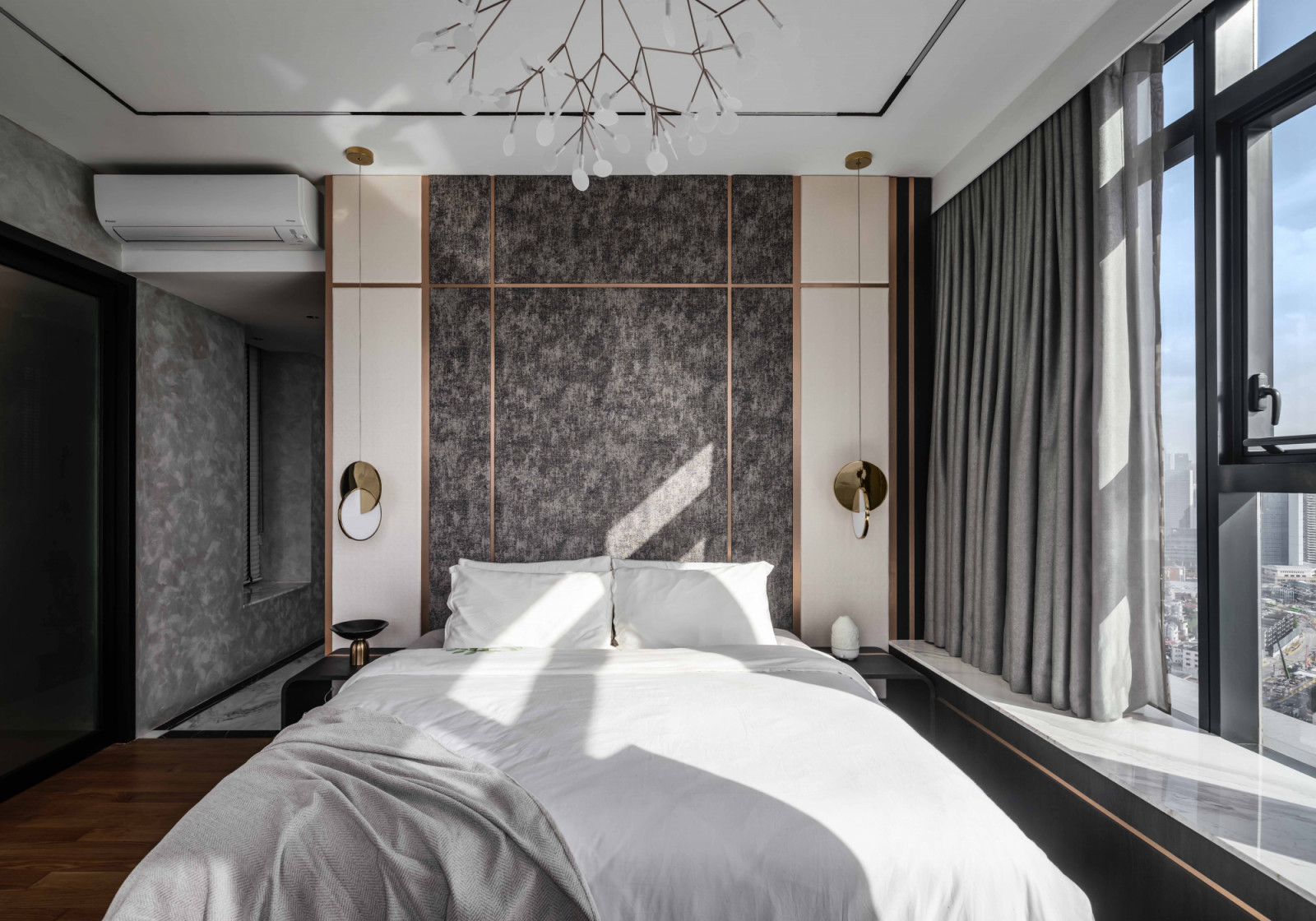 Curvy details like pendant lights and Moooi’s Heracleum lights lend femininity into this monochromatic bedroom
