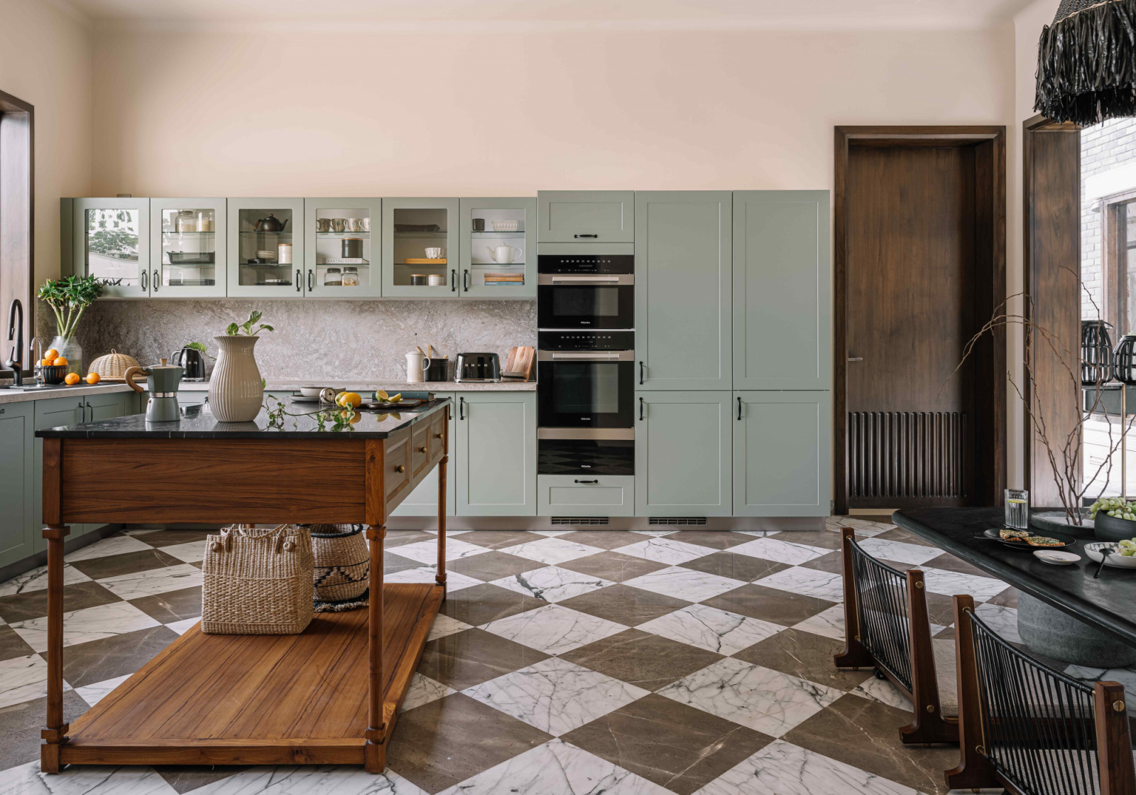 The kitchen area with pastel green cabinetry and wooden accents