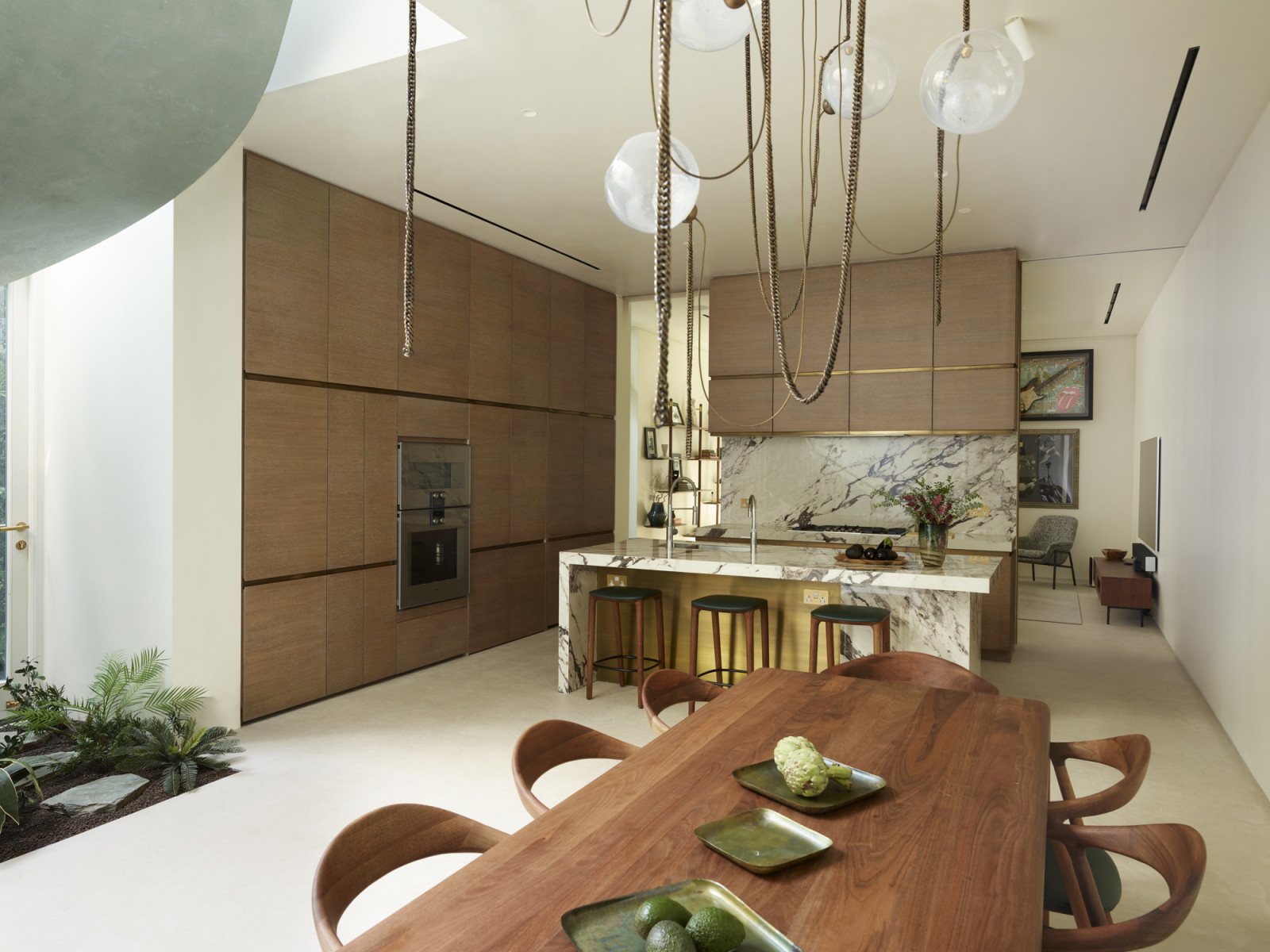 The dining room and kitchen area on the basement level of a Kensington, London home designed by Boundary Space