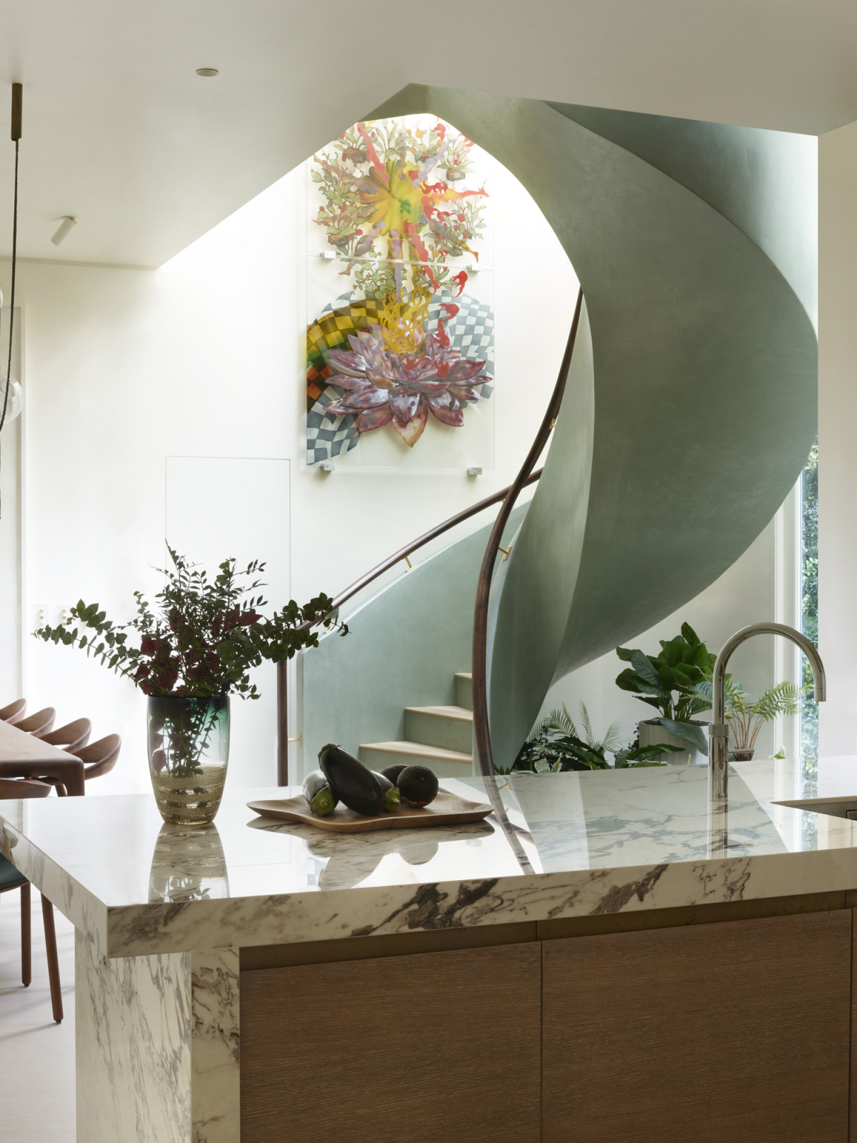 The kitchen area with views of the terrazzo staircase on the basement level of a Kensington, London home designed by Boundary Space