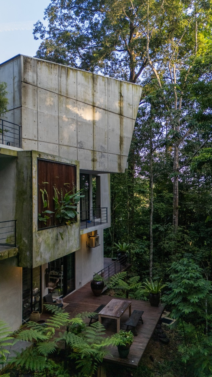 The monolithic concrete structure creates a striking contrast with the greenery