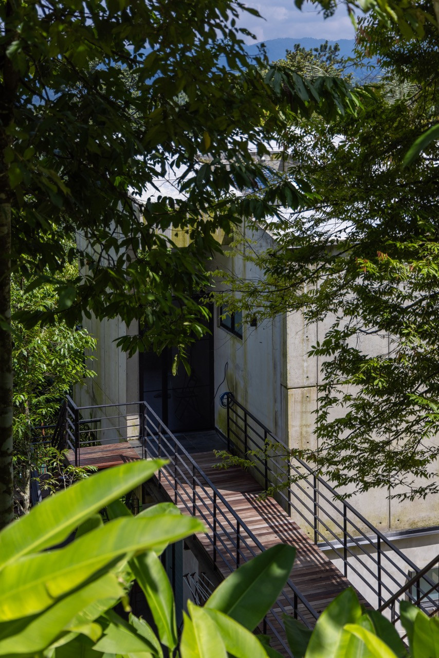 Timber walkways and steel railings create the semi-outdoor circulation that connects different areas of the house