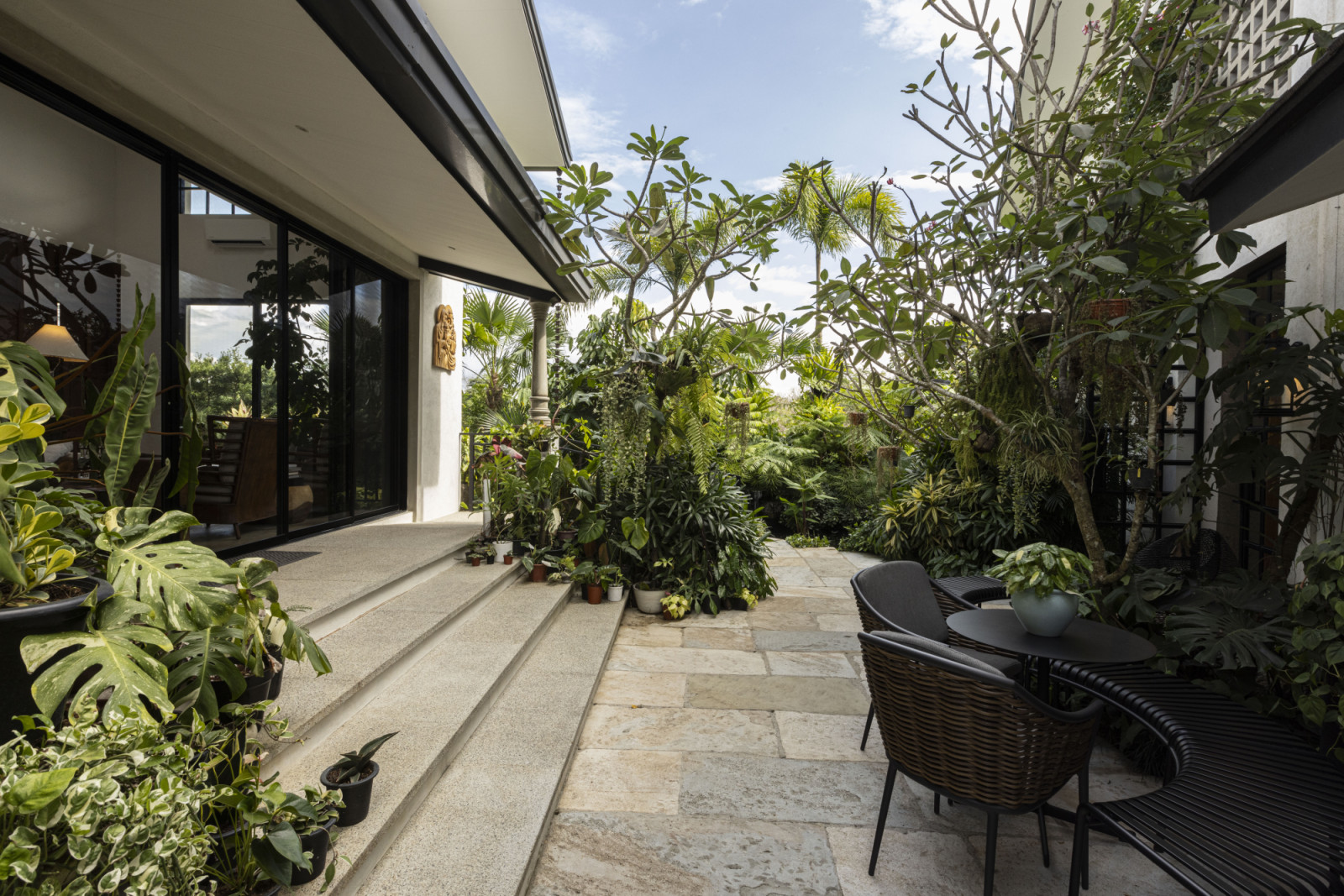 A glimpse of the thriving outdoor area of a verdant Laguna, Philippines family home designed by architect Miko Delos Reyes