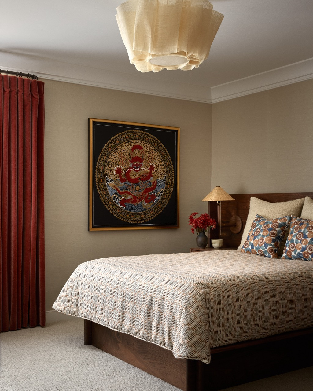 The bedroom in burnt orange and wheat tones features a vintage dragon artwork that reflects the couple's art collection and well-travelled aesthetic