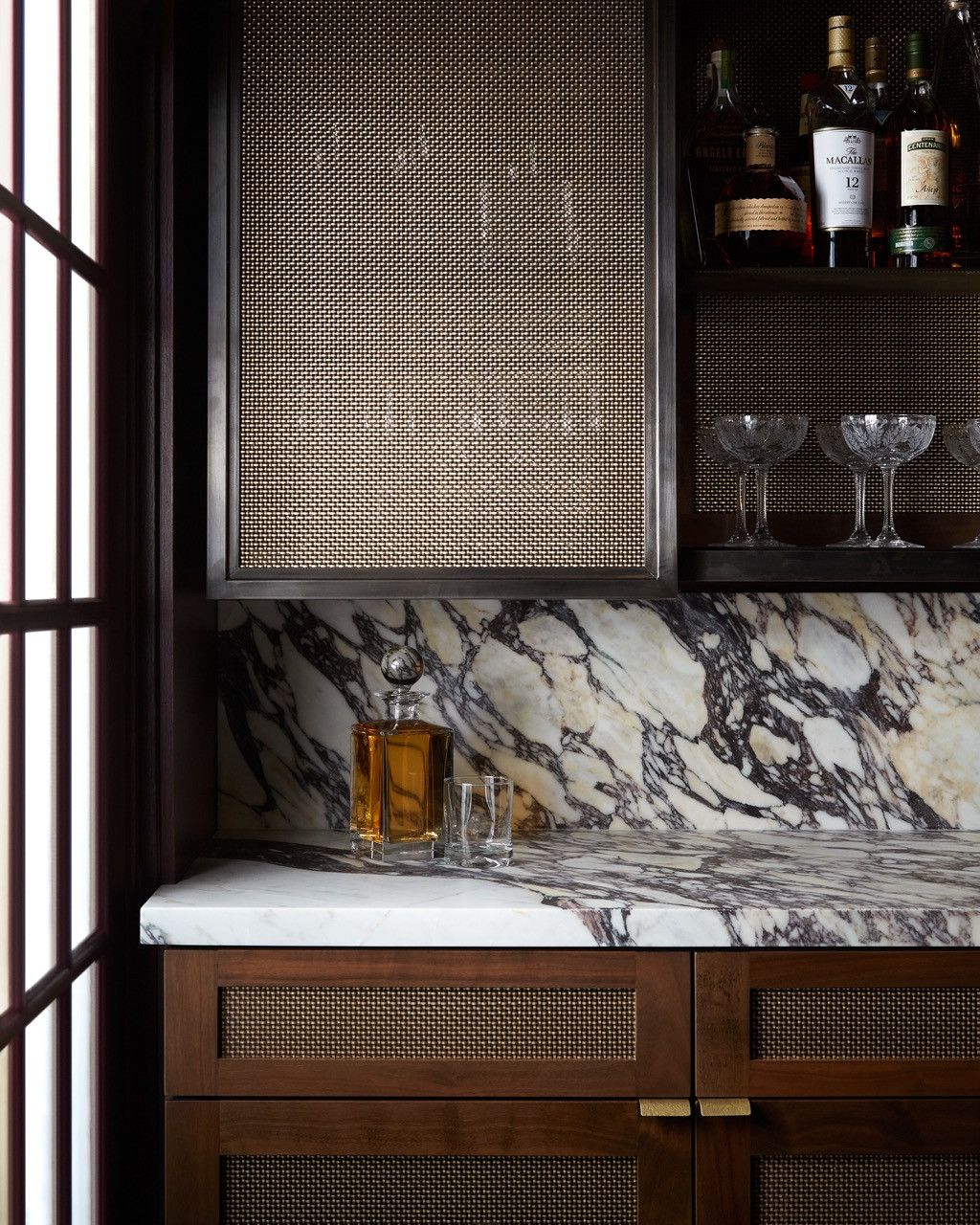 The bar area showcases dramatic veining in the marble countertops, creating a luxurious focal point in the entertaining space