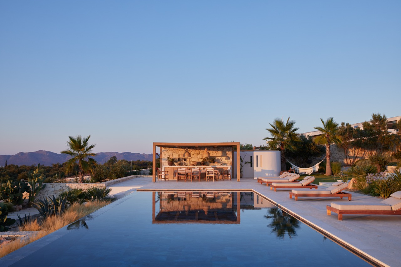 The dining area and pool terrace sit beneath clear skies with the White Mountains forming a backdrop